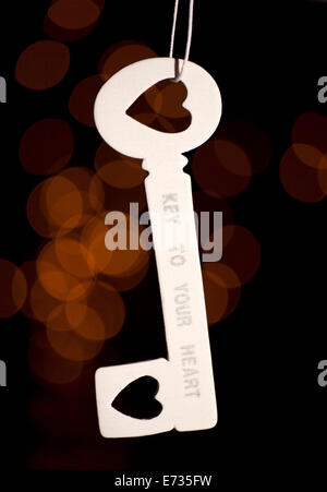 White key hanging on the rope. On a black background with bokeh. Stock Photo