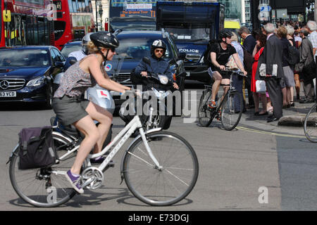 A female cyclist crossing a busy junction in Parliament Square, London. Stock Photo