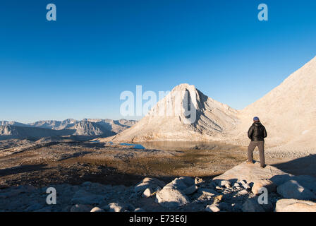 Hiker looking over Royce Lakes and Merriam Peak, High Sierra Stock Photo