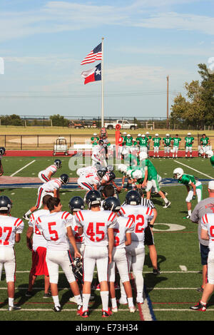 High school junior varsity football game being played under US and Texas flags Stock Photo