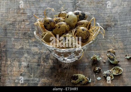 Quail eggs in a glass bowl in an old wooden table Stock Photo
