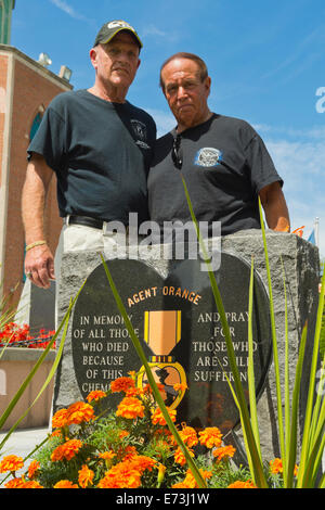 East Meadow, New York, USA. 3rd September, 2014.  L-R, PAT YNGSTROM, of Merrick, U.S. Army Paratrooper, Vietnam War Veteran, and STEVE BONOM, of Massapequa, U.S. Navy, Vietnam War Veteran, are standing behind the Agent Orange Monument at Eisenhower Park, after participating in a press conference held by congressional candidate K. Rice. They are members of Rice's newly formed Veterans Advisory Committee, and casualties of Agent Orange during the Vietnam War. Credit:  Ann E Parry/Alamy Live News Stock Photo