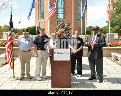 East Meadow, New York, USA. 3rd September, 2014.  KATHLEEN RICE, at podium, Democratic congressional candidate (NY-04), announces formation of her campaign's Veterans Advisory Committee, at Veterans Memorial at Eisenhower Park. Congresswoman CAROLYN MCCARTHY (in white jacket) and 4 committee members joined Rice at press conference: speaking is JEREMIAH E. BRYANT, of Rockville Centre, U.S. Army, Vietnam War Veteran; & veterans STEVE BONOM, of Massapequa, U.S. Navy, Vietnam War; PAT YNGSTROM, Merrick, US Army Vietnam War, & PAUL ZYDOR, Merrick, US Navy, Korean War.  Credit:  Ann E Parry/Alamy Li Stock Photo