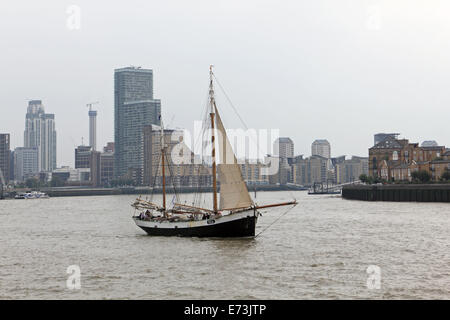 London, UK. 5th September, 2014.  The sailing lugger Tecla passes Canary Wharf on the River Thames. This is one of the boats attending the Tall Ships Festival 2014 which takes place in Woolwich, Maritime Greenwich, Greenwich Peninsula and Canary Wharf, from 5 to 9 Septembe. 50 Tall Ships will be attending the festival and will be moored for viewing at the various locations, as well as being sailed along the Thames. Credit:  Julia Gavin UK/Alamy Live News Stock Photo