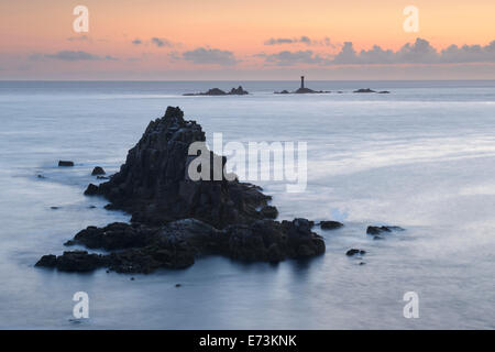 The rocky island known as the Armed Knight with Longships Lighthouse in the distance, off the coast of Land's End, Cornwall. Stock Photo