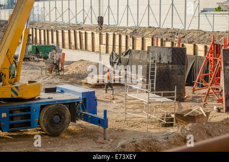 construction site with workers heavy machinery foundations handling and scaffolding Stock Photo