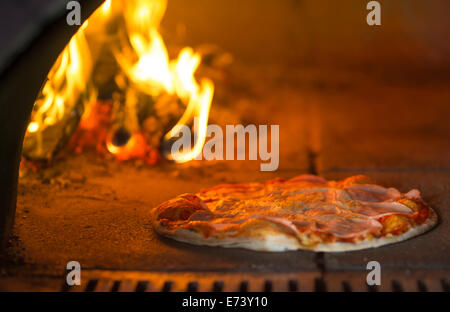 Pizza baking in traditional oven Stock Photo