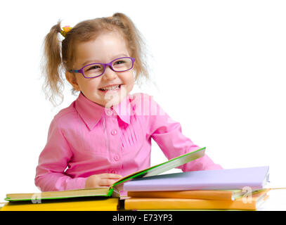 Happy child girl in glasses reading books sitting at table