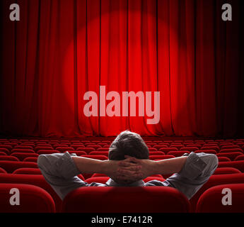 man sitting alone in  empty theater or cinema hall Stock Photo