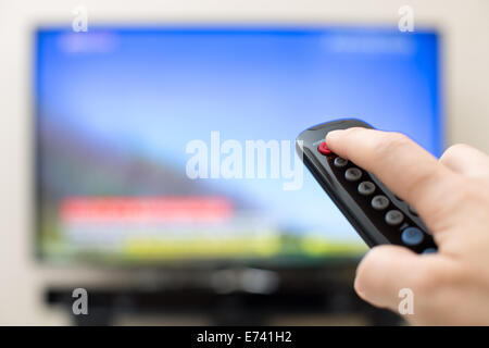 Power button pressing on TV remote control Stock Photo