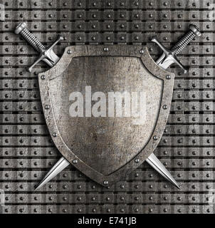 Shield and two swords crossed hanging on metal wall with rivets Stock Photo