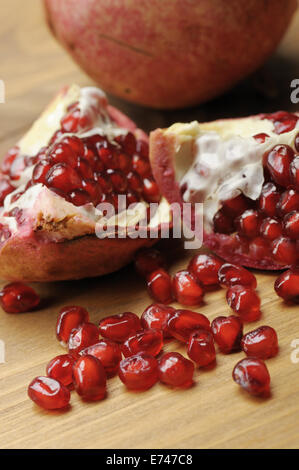 closeup of pomegranate grains on wooden table Stock Photo