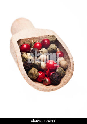 Mixed peppercorns in a wooden spoon on a white background Stock Photo