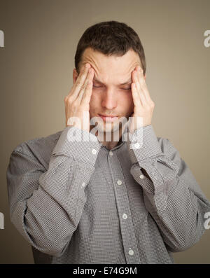 Young Caucasian man with headache, casual studio portrait Stock Photo