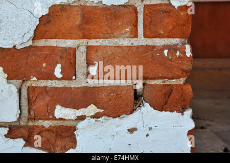 Chipped stucco on brick wall
