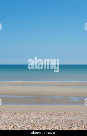 The wide sandy beach, blue sea and blue sky at Pett Level in Sussex on a beautiful sunny day Stock Photo