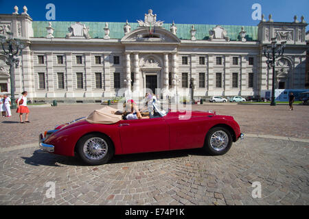 Torino, Italy. 6th September 2014. A 1958 Jaguar XK 150 DHC arrives in Piazza Carlo Alberto, Torino. In the background Torino National Library. Collectors of historical cars met in Torino for a car elegance competition. Stock Photo