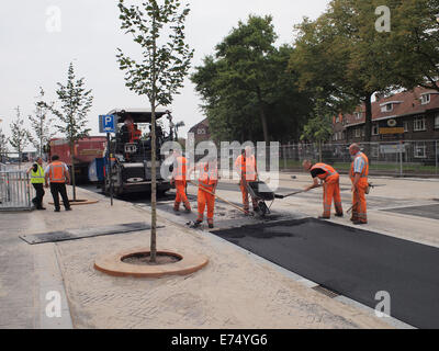 Men putting tarmac top coat on the new Stationslaan road in Breda, the Netherlands Stock Photo