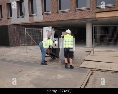 Workers moving office furniture into new building, Breda Central Station, the Netherlands Stock Photo