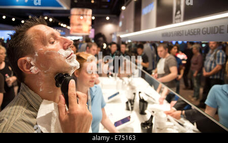 Berlin, Germany. 07th Sep, 2014. A visitor tests an electric razor at the Philips trade fair stand on the third day of the electronics trade fair IFA in Berlin, Germany, 07 September 2014. IFA takes place from 5 September - 10 September in Berlin. PHOTO: JOERG CARSTENSEN/DPA/Alamy Live News Stock Photo