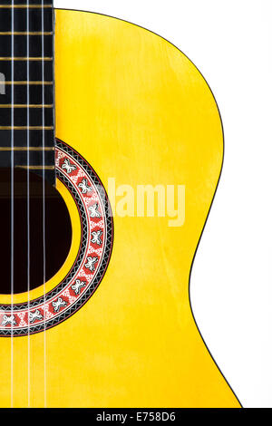 Detail view of yellow wooden classical acoustic guitar, isolated on white background.