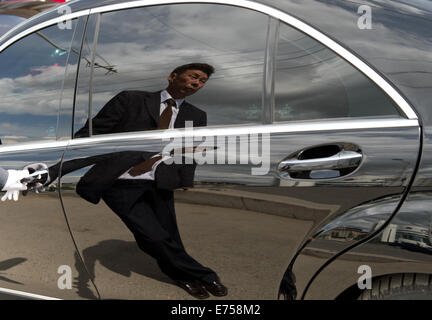 (FILE) An archive picture, dated 06 July 2014, shows a chauffeur in a suit with white gloves waiting for his passenger in Ulan Bator, Mongolia. Photo: Soeren Stache/dpa Stock Photo