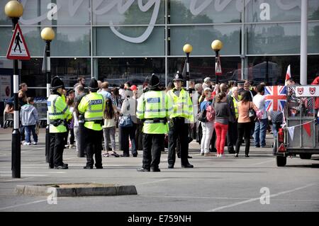 Gorton, Manchester, UK. 7th Sep, 2014. Gorton Carnival Parade on way to Debdale Park, with a stop on Tesco car park, Gorton, for several of the groups in the parade to perform for spectators.-Police and spectators on Tesco car park Stock Photo