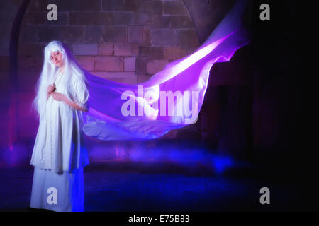 White haired ghost in a castle with her dress in the wind Stock Photo
