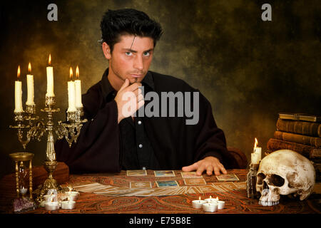 Halloween scene of a young astrologist reading tarot cards Stock Photo