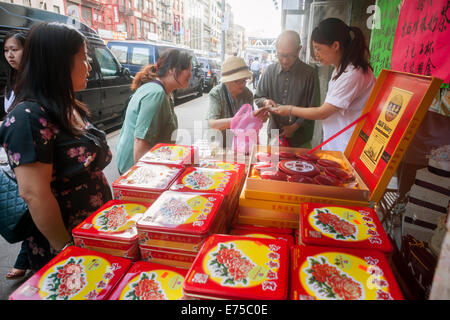 New York, USA. 7th September, 2014. Shoppers in Chinatown in New York buy boxes of mooncakes on Sunday, September 7, 2014 for the Mid-Autumn Festival which occurs on September 8. The delicious traditional baked product is eaten during the Mid-Autumn festival and are popular as gifts. The perfectly round pastries can be sweet or savory, filled with lotus seed or salted duck egg. The cakes represent the full moon on the eighth month, the fifteenth day in the Chinese (lunar) calendar. Credit:  Richard Levine/Alamy Live News Stock Photo