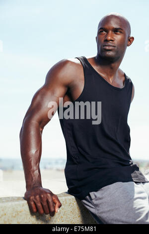 Portrait of handsome young African male model looking away. Muscular young man outdoors. Stock Photo