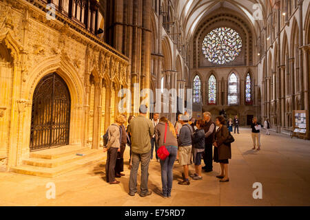 Lincoln Cathedral interior, people on a guided tour in the South transept, with the Bishops eye stained glass window Lincoln UK Stock Photo