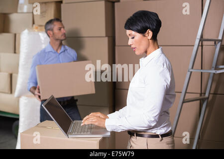 Pretty warehouse manager using laptop Stock Photo
