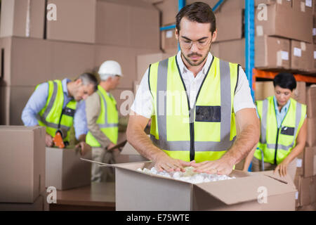Warehouse workers in yellow vests preparing a shipment Stock Photo