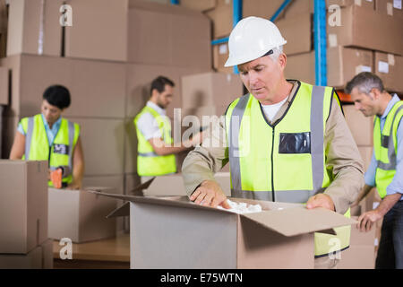 Warehouse workers in yellow vests preparing a shipment Stock Photo