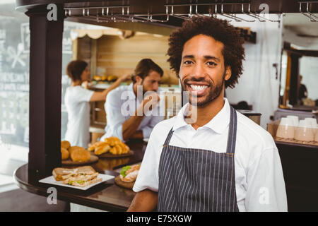 Handsome waiter smiling at camera Stock Photo