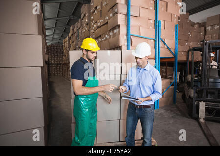 Warehouse worker loading up a pallet with manager Stock Photo