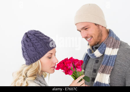 Attractive couple in warm clothing holding flowers Stock Photo