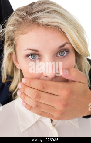 Hand covering young woman's mouth Stock Photo