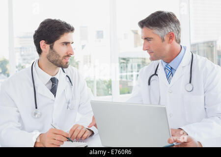 Doctor sitting and taking notes Stock Photo