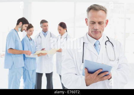 Serious doctor using his tablet Stock Photo