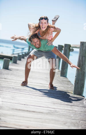 Couple playing on wooden dock Stock Photo