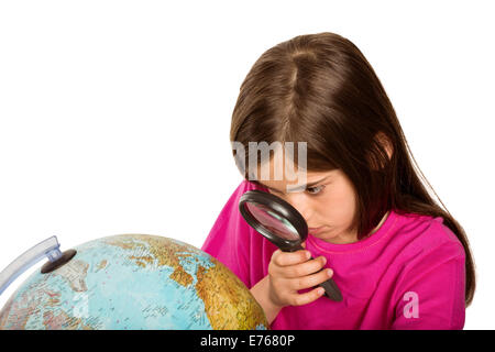 Cute pupil looking at globe through magnifying glass Stock Photo