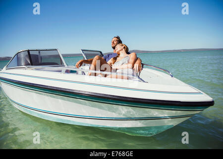 Couple sitting in boat on water Stock Photo