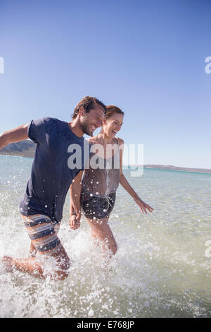 Couple splashing in water together Stock Photo