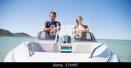 Couple standing in boat on water Stock Photo