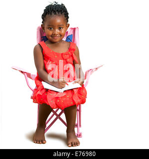 Full length portrait of little African girl sitting with note book.Isolated on white background. Stock Photo