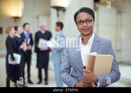 Lawyer standing with documents in courthouse Stock Photo