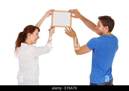 Couple hanging picture on wall Stock Photo