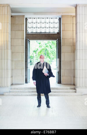 Judge standing in front of doors to courthouse Stock Photo